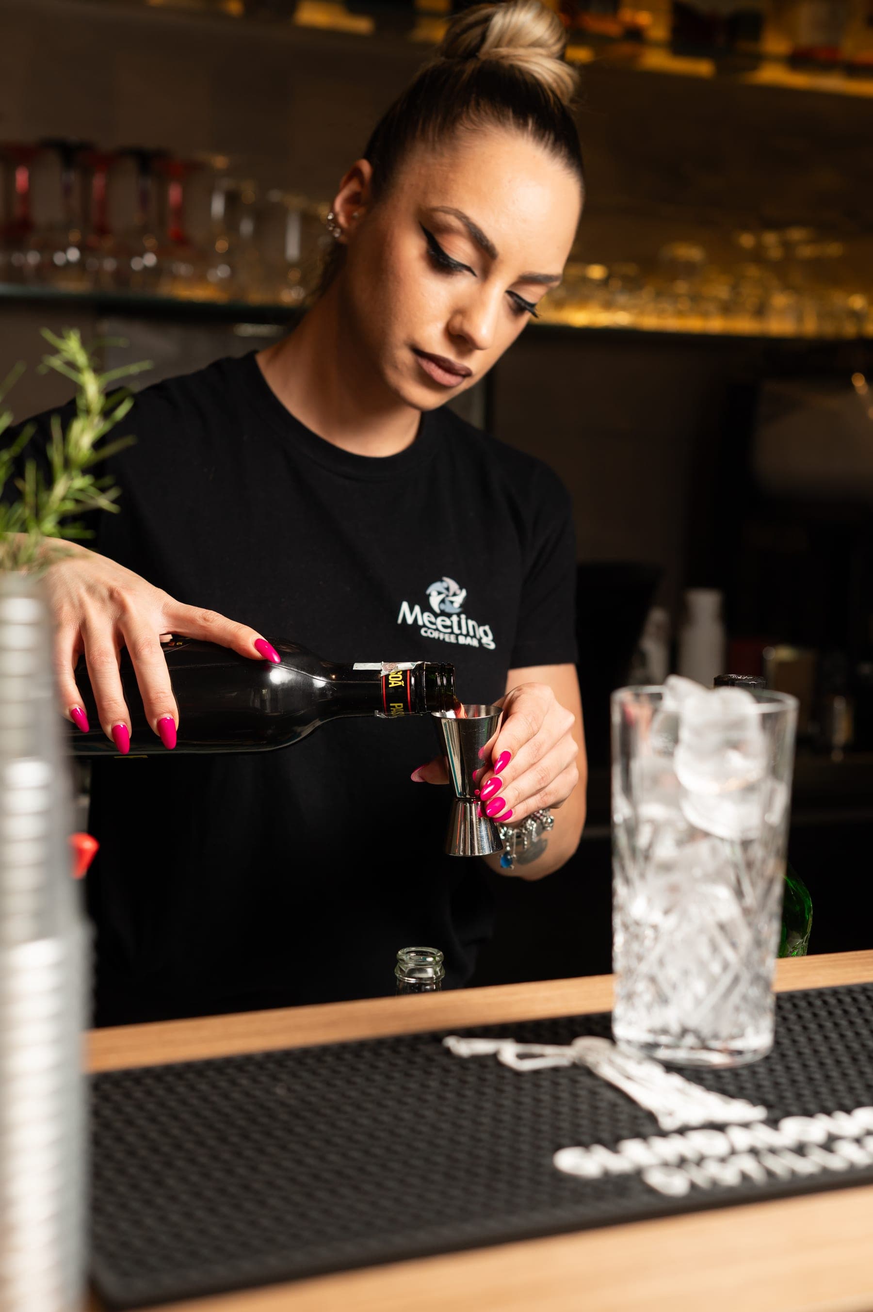 Una barista del Meeting Coffee Bar versa da bere al bancone